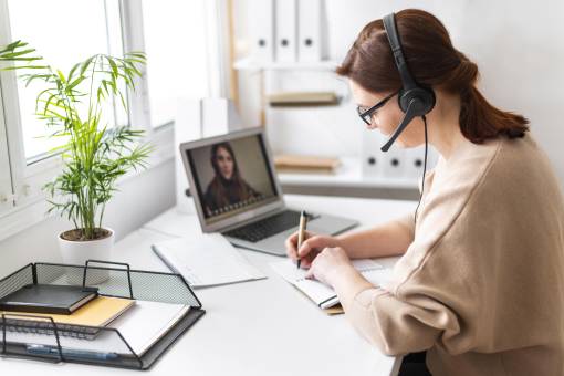 portrait woman at work having video call on laptop